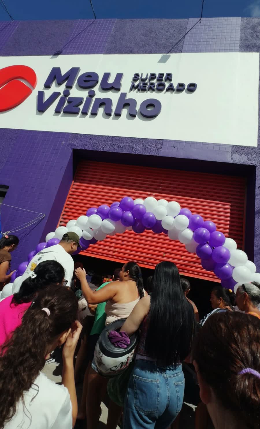 Clientes na entrada do Meu Vizinho Supermercado